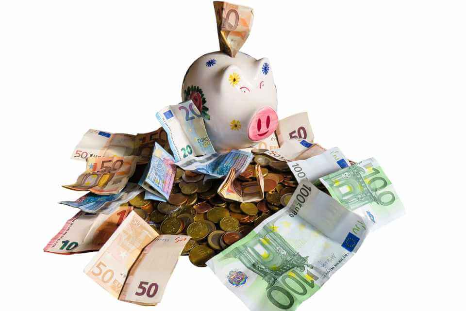 Sparschwein in Euro-Bargeld: Kreditrate zu hoch? Tipps zum Kredit günstiger machen und für niedrige Kreditzinsen.